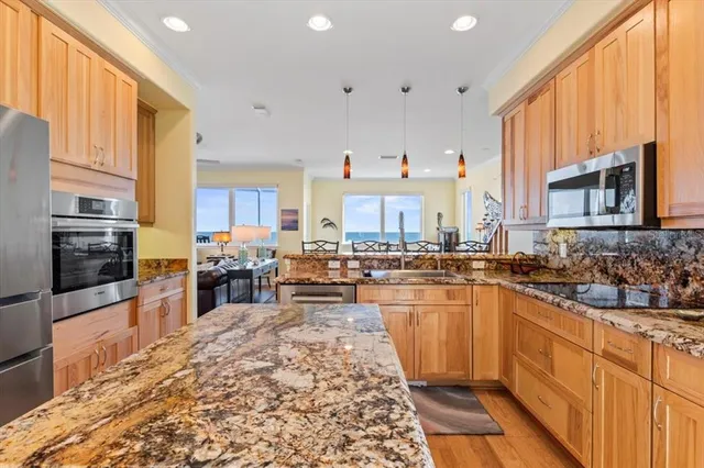 a kitchen with kitchen island granite countertop a sink stove and cabinets