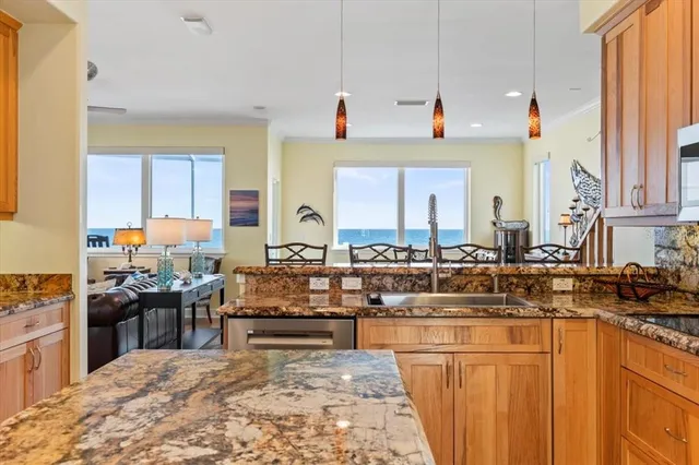 a kitchen with stainless steel appliances granite countertop a sink a stove and a wooden floors