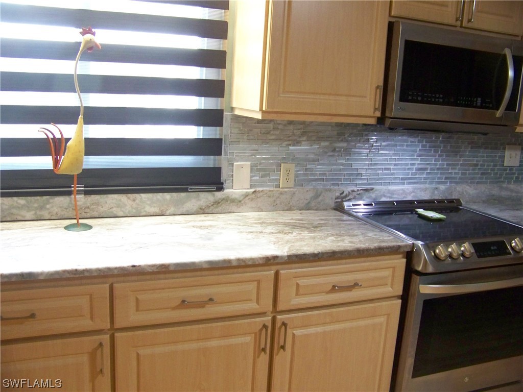 15550 Burnt Store Road, Unit 51 Punta Gorda, FL 33955 - Photo 19 of 50 a kitchen with granite countertop a sink stainless steel appliances and cabinets