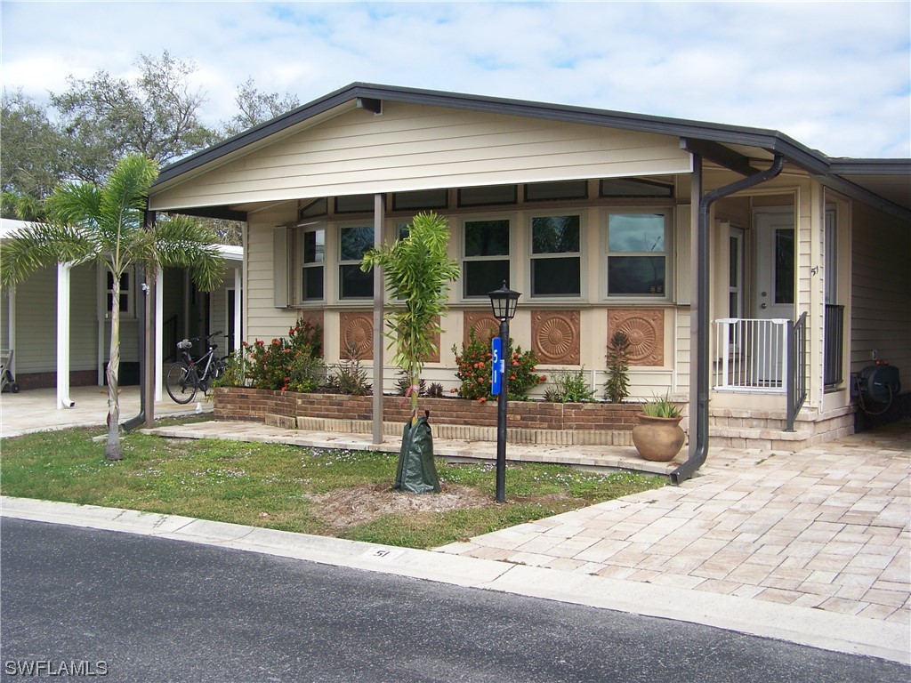 15550 Burnt Store Road, Unit 51 Punta Gorda, FL 33955 - Photo 3 of 50 a front view of a house with a yard and porch