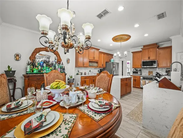 a kitchen with stainless steel appliances granite countertop a stove top oven a sink dishwasher a dining table and chairs with wooden floor