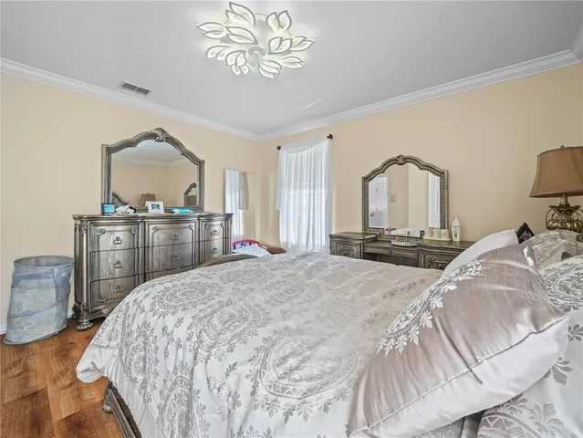 a bedroom with a large bed and a chandelier
