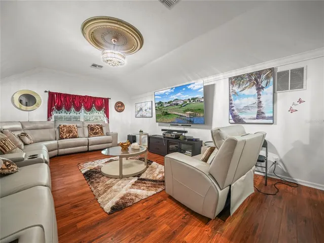 a bedroom with a large bed and a chandelier