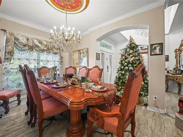 a dining room with furniture a chandelier and wooden floor