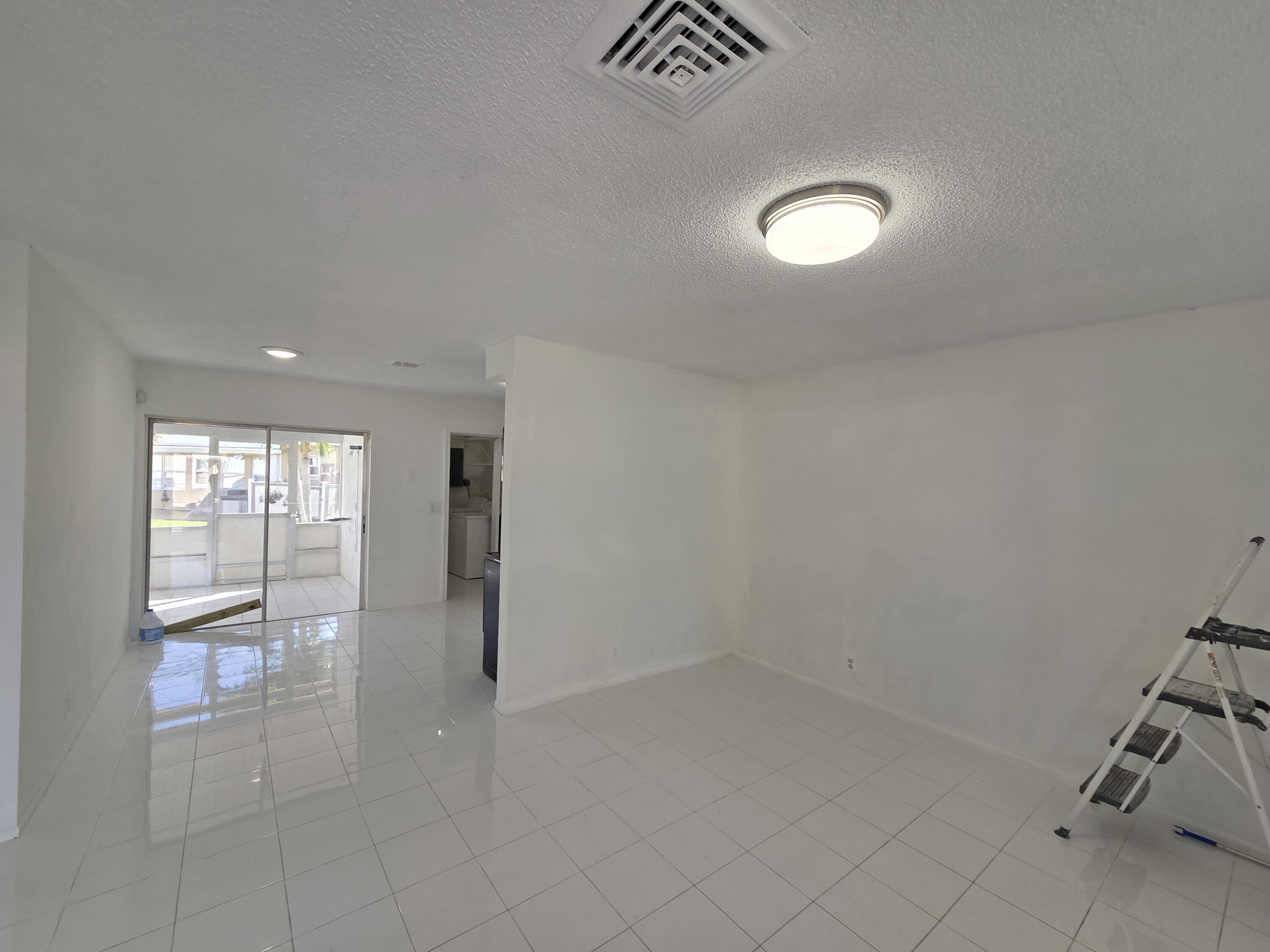 2847 Duke Lane Delray Beach, FL 33445 - Photo 3 of 17 an empty room with chandelier fan and windows