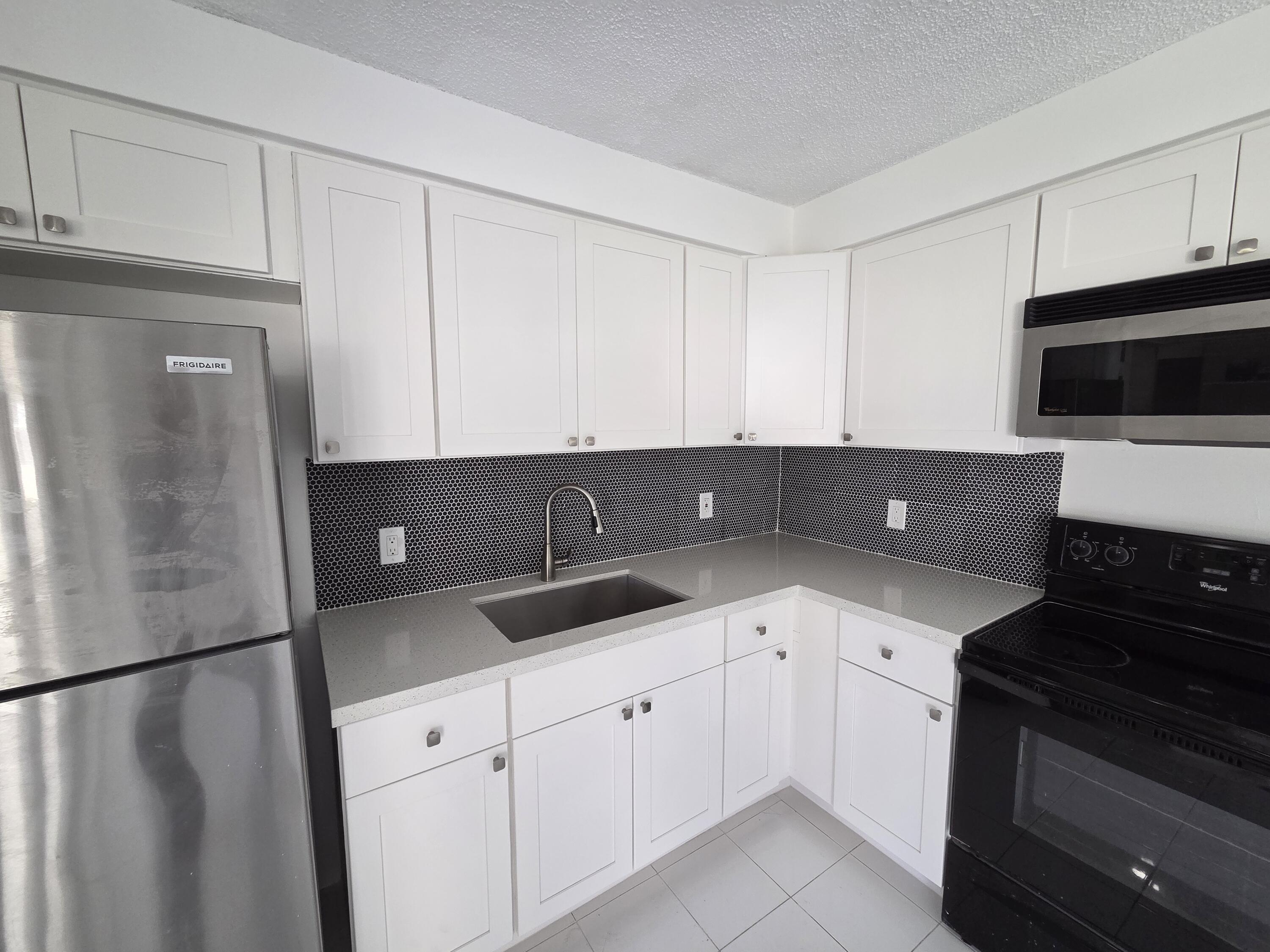 2847 Duke Lane Delray Beach, FL 33445 - Photo 6 of 17 a kitchen with a sink and a stove top oven