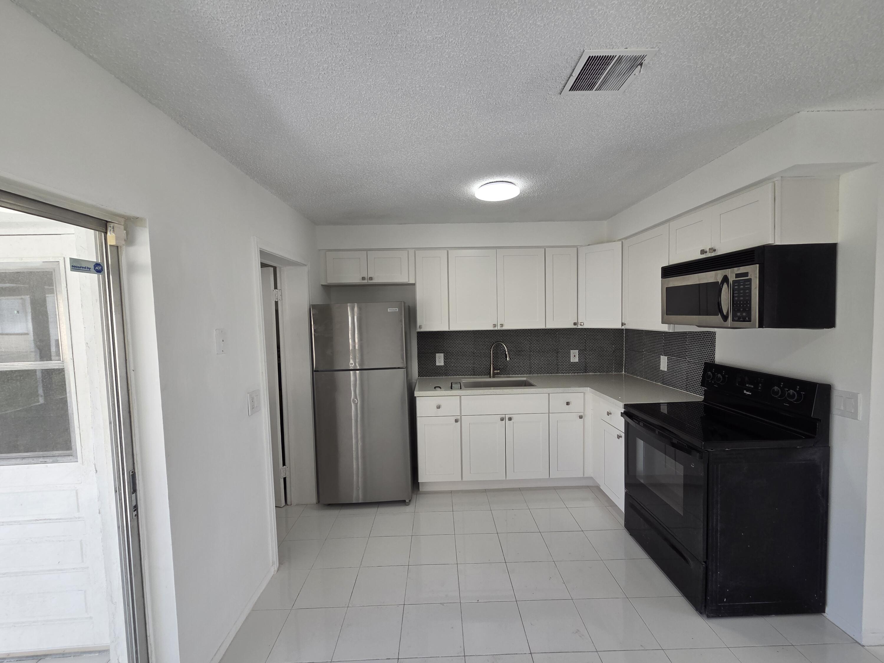 2847 Duke Lane Delray Beach, FL 33445 - Photo 7 of 17 a kitchen with a refrigerator and a sink