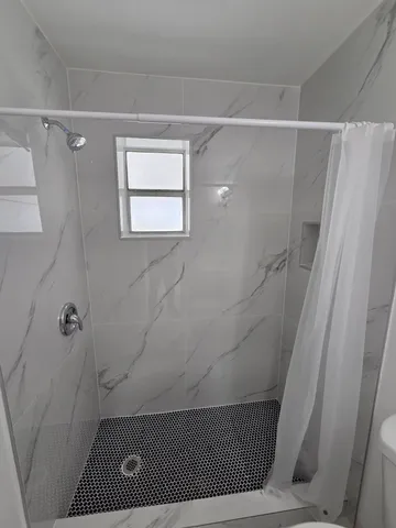 a bathroom with a toilet and a shower