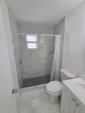 a bathroom with a toilet and a shower