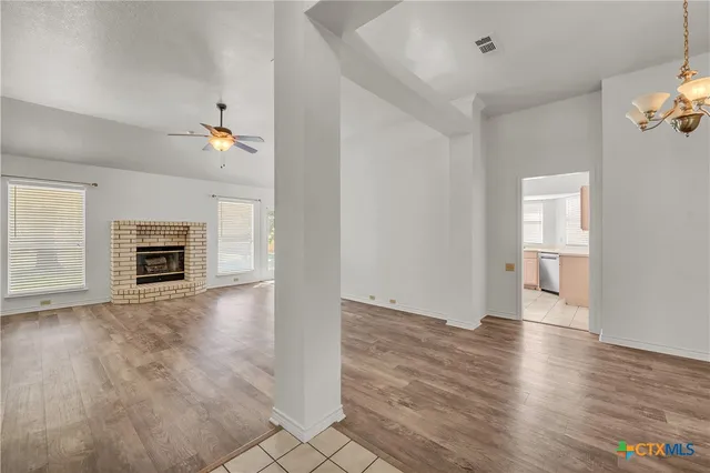 an empty room with wooden floor and fireplace