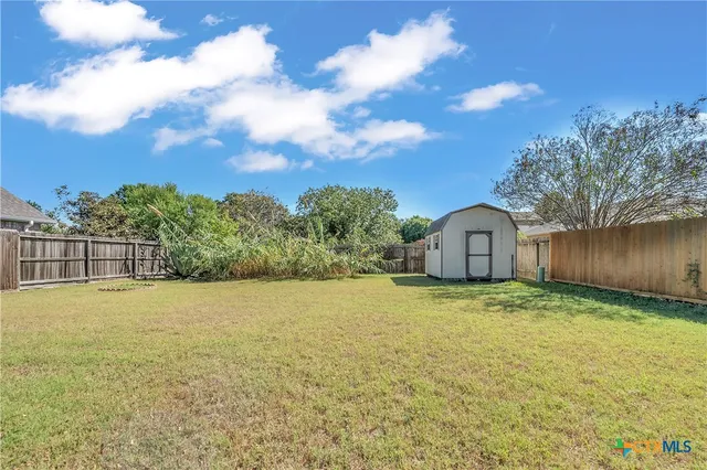 a view of large trees with wooden fence