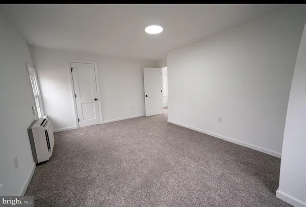 an empty room with windows and ceiling fan