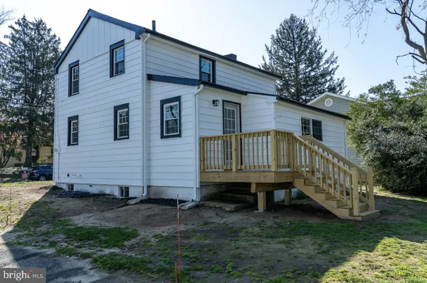 a view of a house with a yard chairs and a small yard