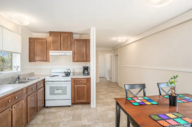 a kitchen with kitchen island granite countertop a sink stove and cabinets