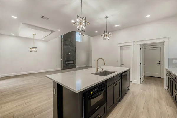 a kitchen with a sink stove and wooden floor