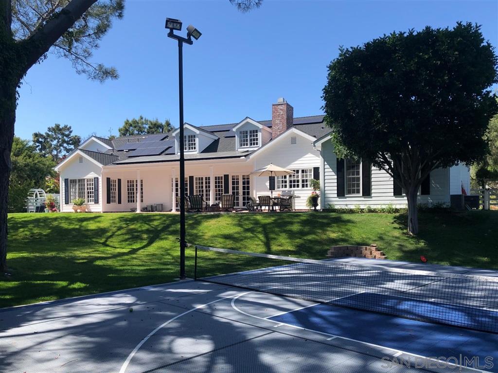 2365 Jennifer Lane Encinitas, CA 92024 - Photo 23 of 25 a view of a white house next to a yard with big trees