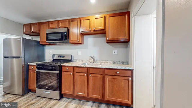 a kitchen with stainless steel appliances granite countertop a refrigerator and a stove top oven