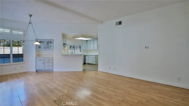 a view of a kitchen with wooden floor and window