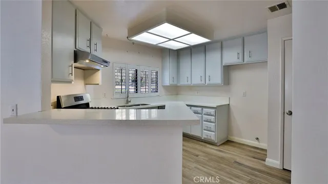 a kitchen with stainless steel appliances granite countertop a sink a stove and a refrigerator