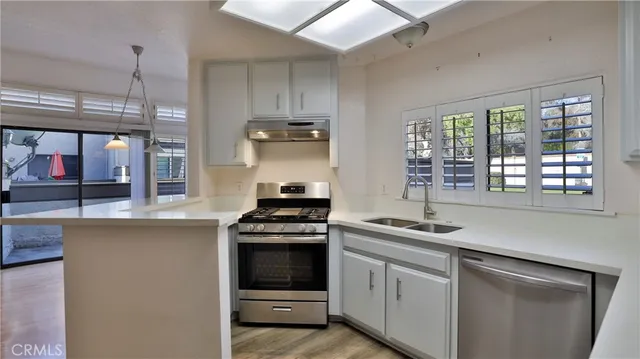 a kitchen with stainless steel appliances granite countertop a sink stove and cabinets