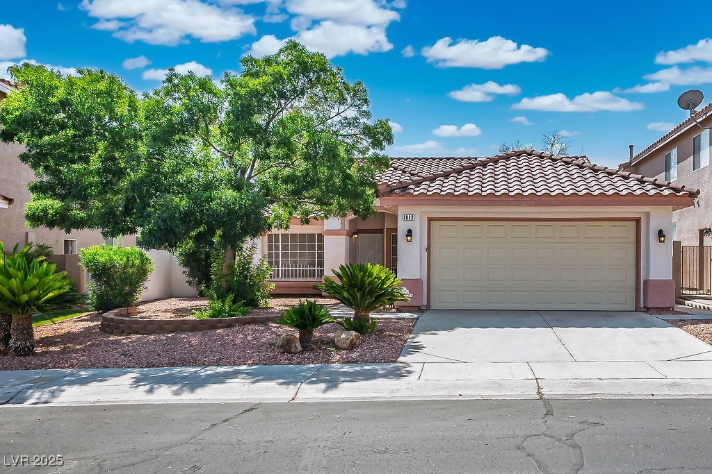 1812 Jack Rabbit Way Las Vegas, NV 89128 - Photo 1 of 44 View of front of home featuring stucco siding, a tile roof, concrete driveway, and an attached garage
