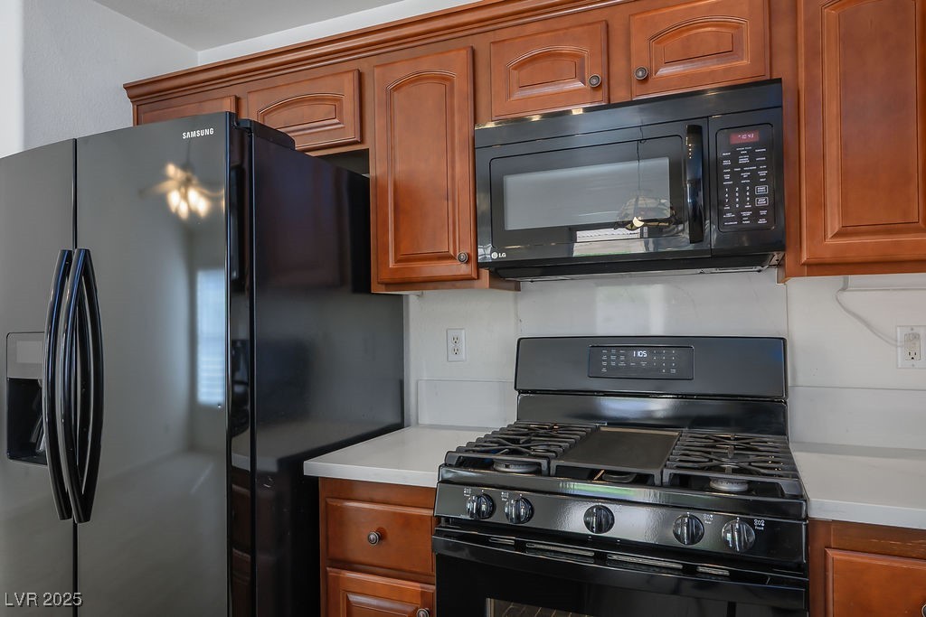 1812 Jack Rabbit Way Las Vegas, NV 89128 - Photo 16 of 44 Kitchen with black appliances and brown cabinetry