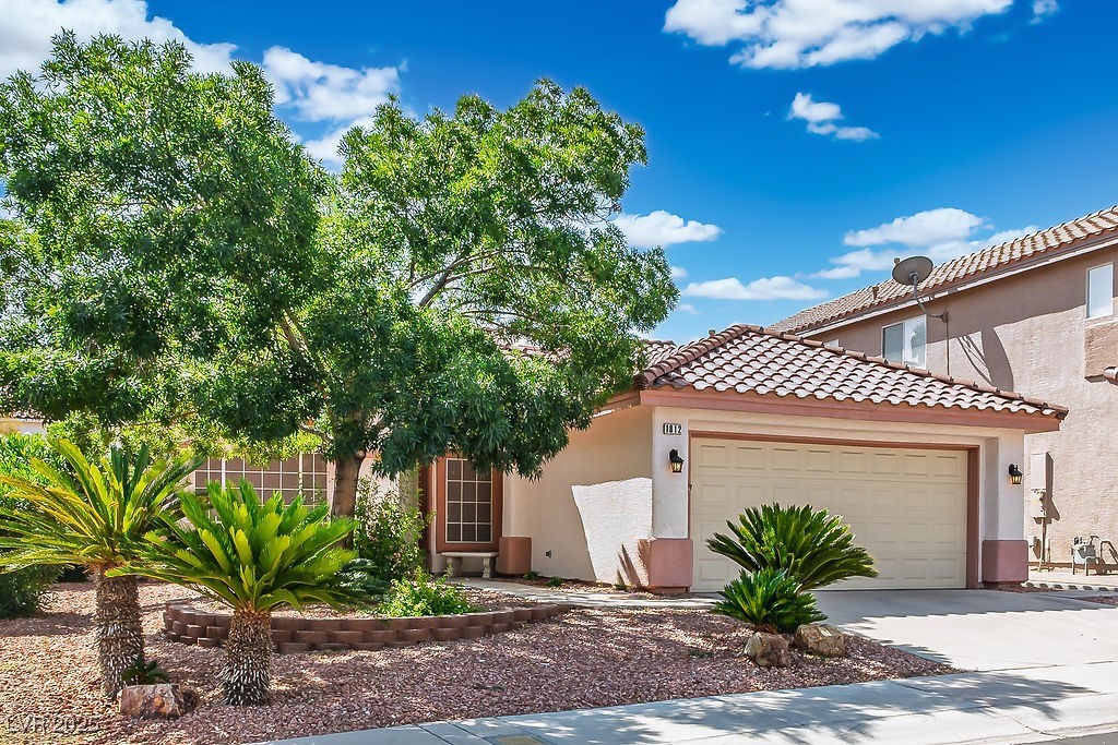 1812 Jack Rabbit Way Las Vegas, NV 89128 - Photo 2 of 44 Mediterranean / spanish-style house featuring stucco siding, a garage, concrete driveway, and a tile roof