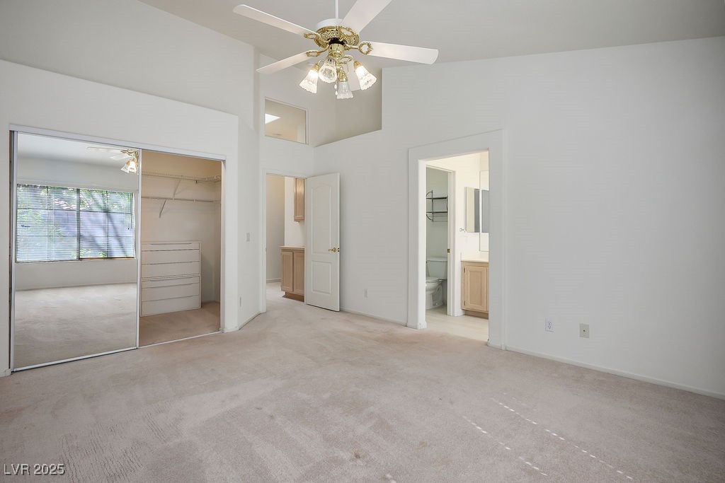 1812 Jack Rabbit Way Las Vegas, NV 89128 - Photo 29 of 44 Master's bedroom featuring mirror closet, ensuite bathroom, and ceiling fan