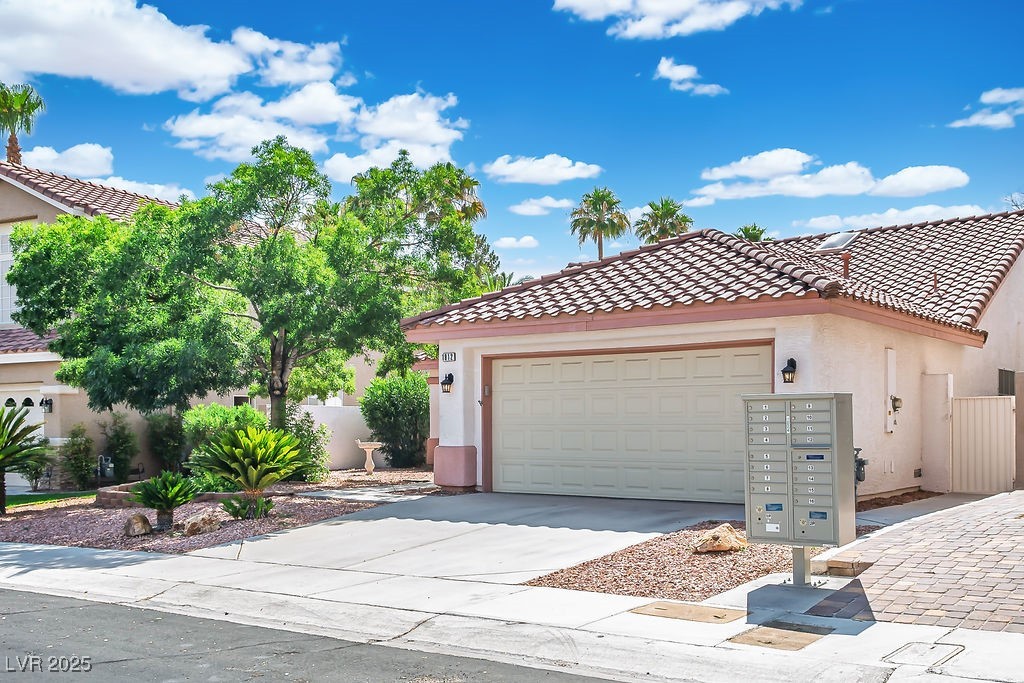 1812 Jack Rabbit Way Las Vegas, NV 89128 - Photo 3 of 44 Mediterranean / spanish house featuring stucco siding, a tiled roof, concrete driveway, and an attached garage