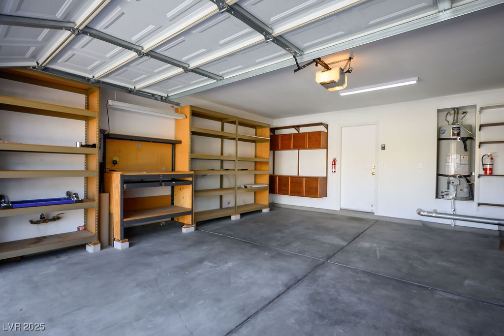 1812 Jack Rabbit Way Las Vegas, NV 89128 - Photo 37 of 44 Garage with water heater, storage shelves, and a garage door opener