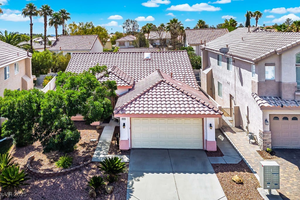 1812 Jack Rabbit Way Las Vegas, NV 89128 - Photo 4 of 44 Mediterranean / spanish house with concrete driveway, stucco siding, a residential view, and an attached garage