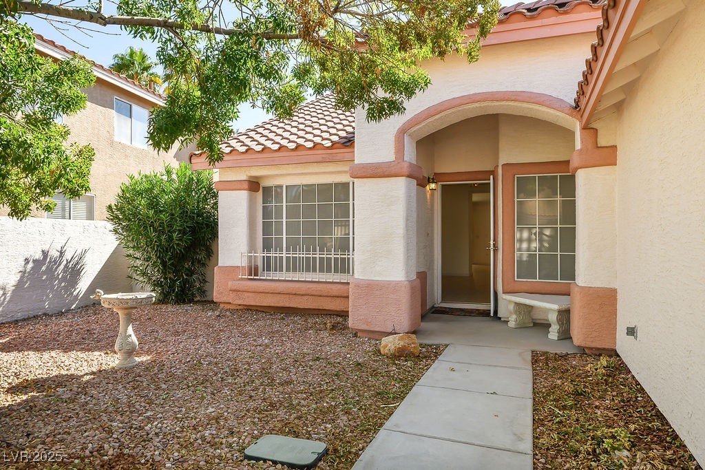 1812 Jack Rabbit Way Las Vegas, NV 89128 - Photo 7 of 44 Entrance to property featuring a tile roof and stucco siding