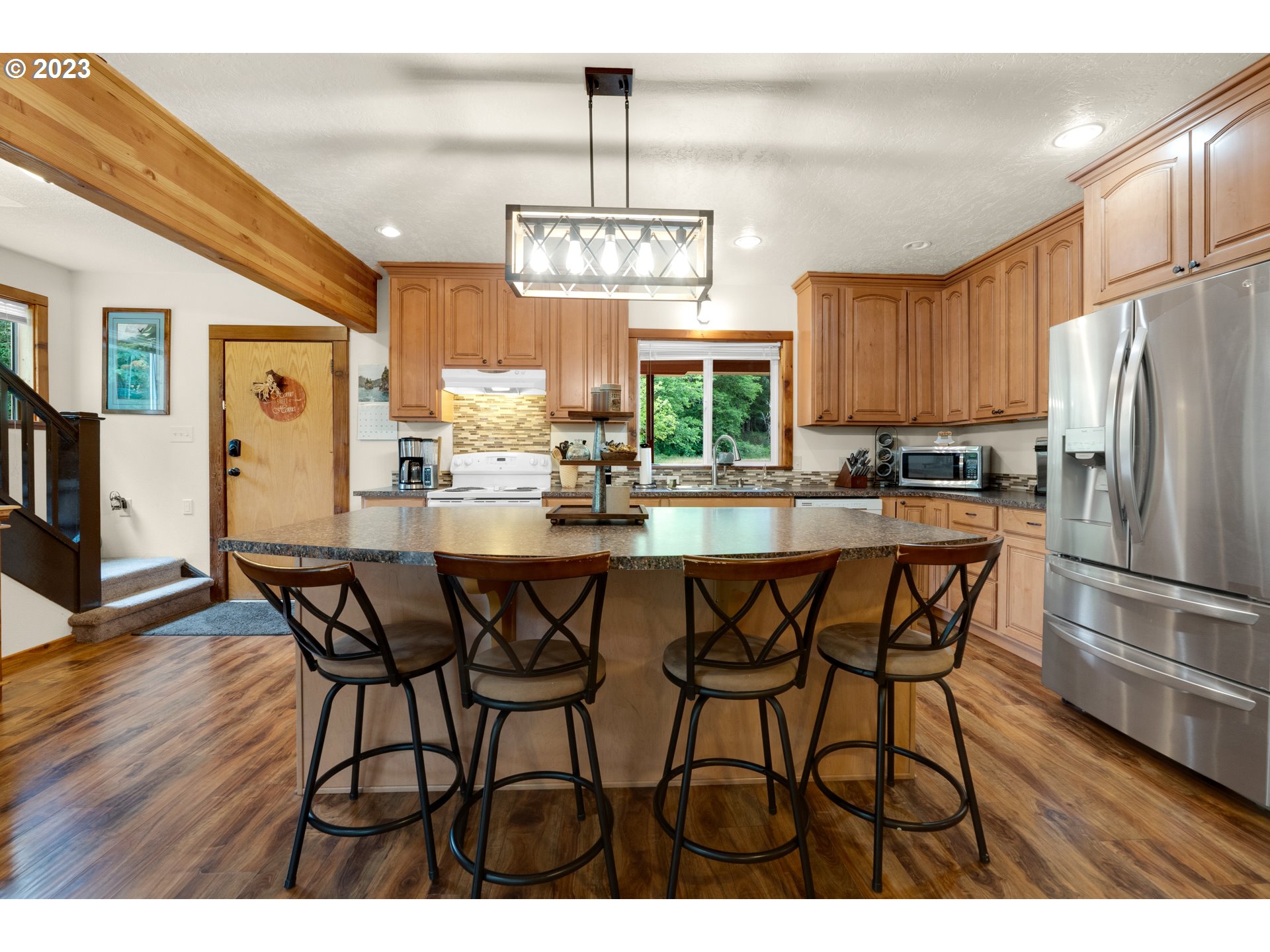 92357 Maki Road Astoria, OR 97103 - Photo 11 of 41 a kitchen with stainless steel appliances a dining table chairs refrigerator and cabinets