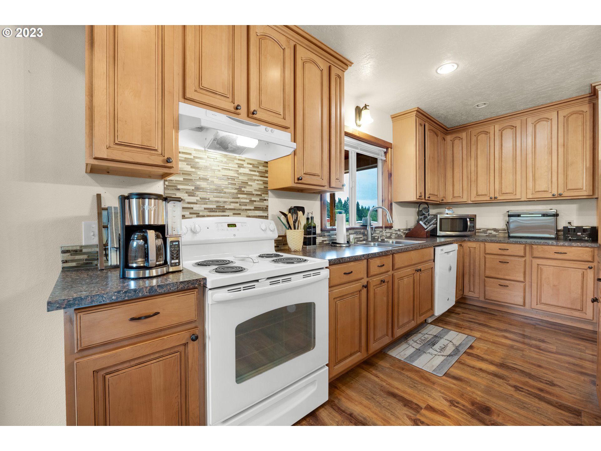 92357 Maki Road Astoria, OR 97103 - Photo 13 of 41 a kitchen with stainless steel appliances granite countertop a stove a sink dishwasher and cabinets with wooden floor