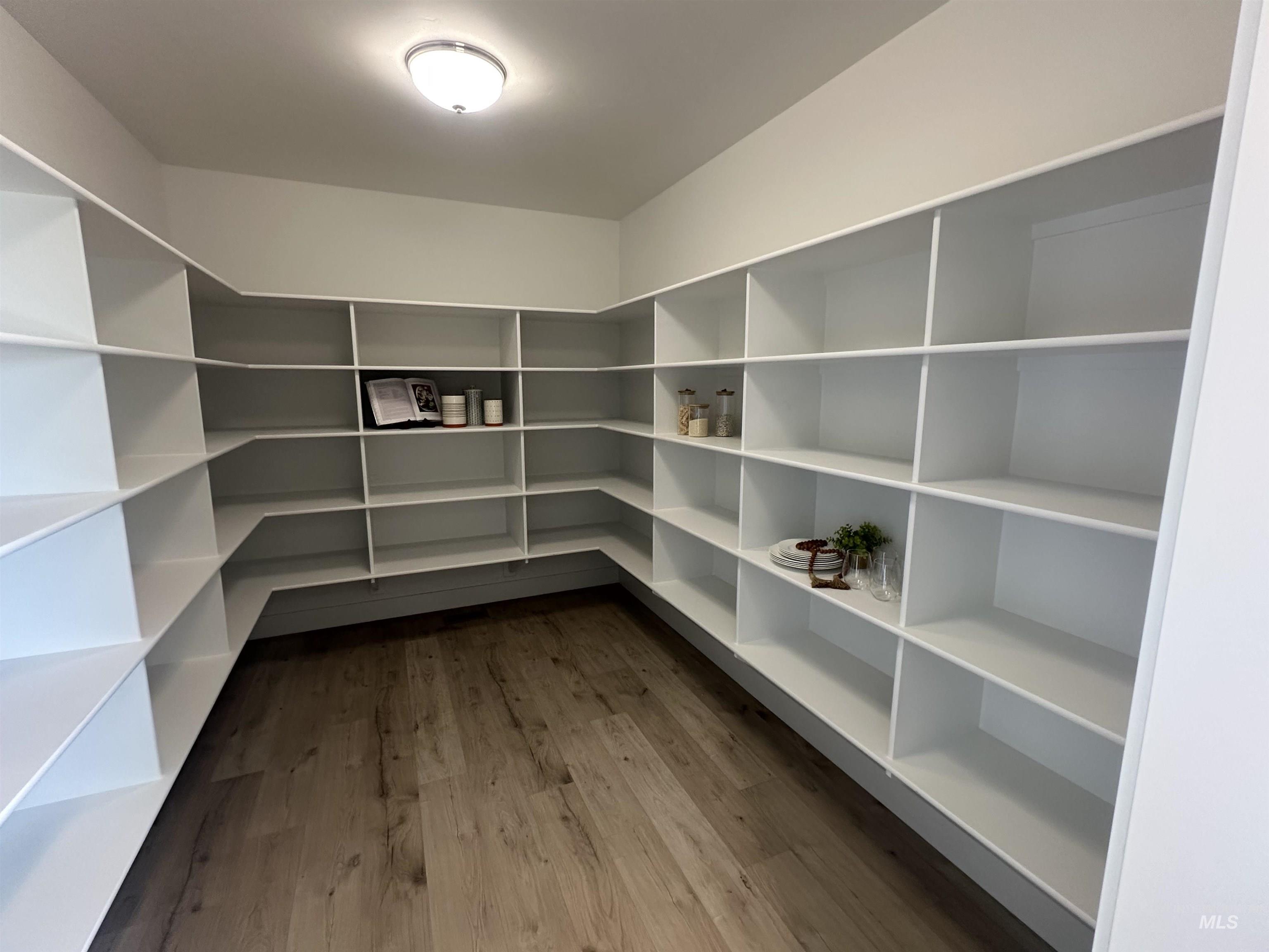 3035 Lake View Twin Falls, ID 83301 - Photo 13 of 41 Walk-in pantry with extensive shelving, complemented by wood-finish flooring, built-in cabinetry, and a subway tile backsplash