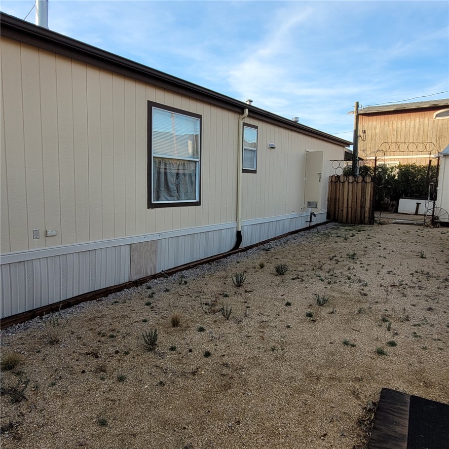 9732 2nd Street Chloride, AZ 86431 - Photo 4 of 28 The property features light-colored siding, dark trim around the windows, and a brown gutter system