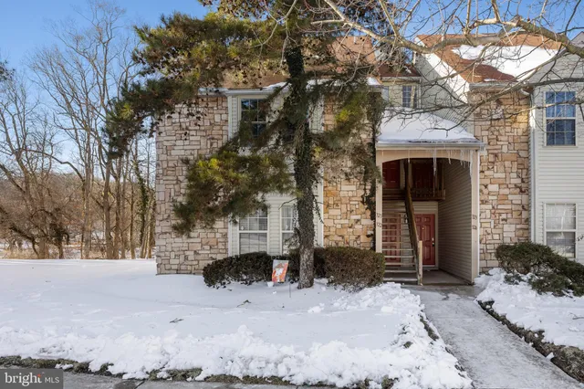 a front view of a building with large trees