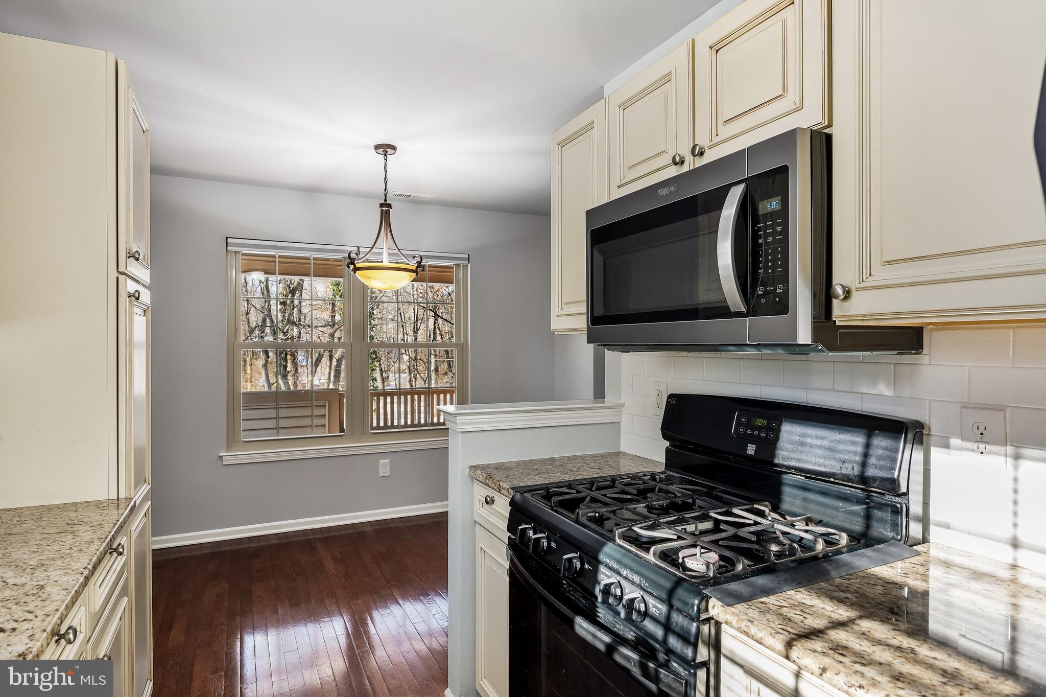 321 Tavistock Road Cherry Hill, NJ 08034 - Photo 8 of 25 a kitchen with granite countertop a stove and a wooden floor