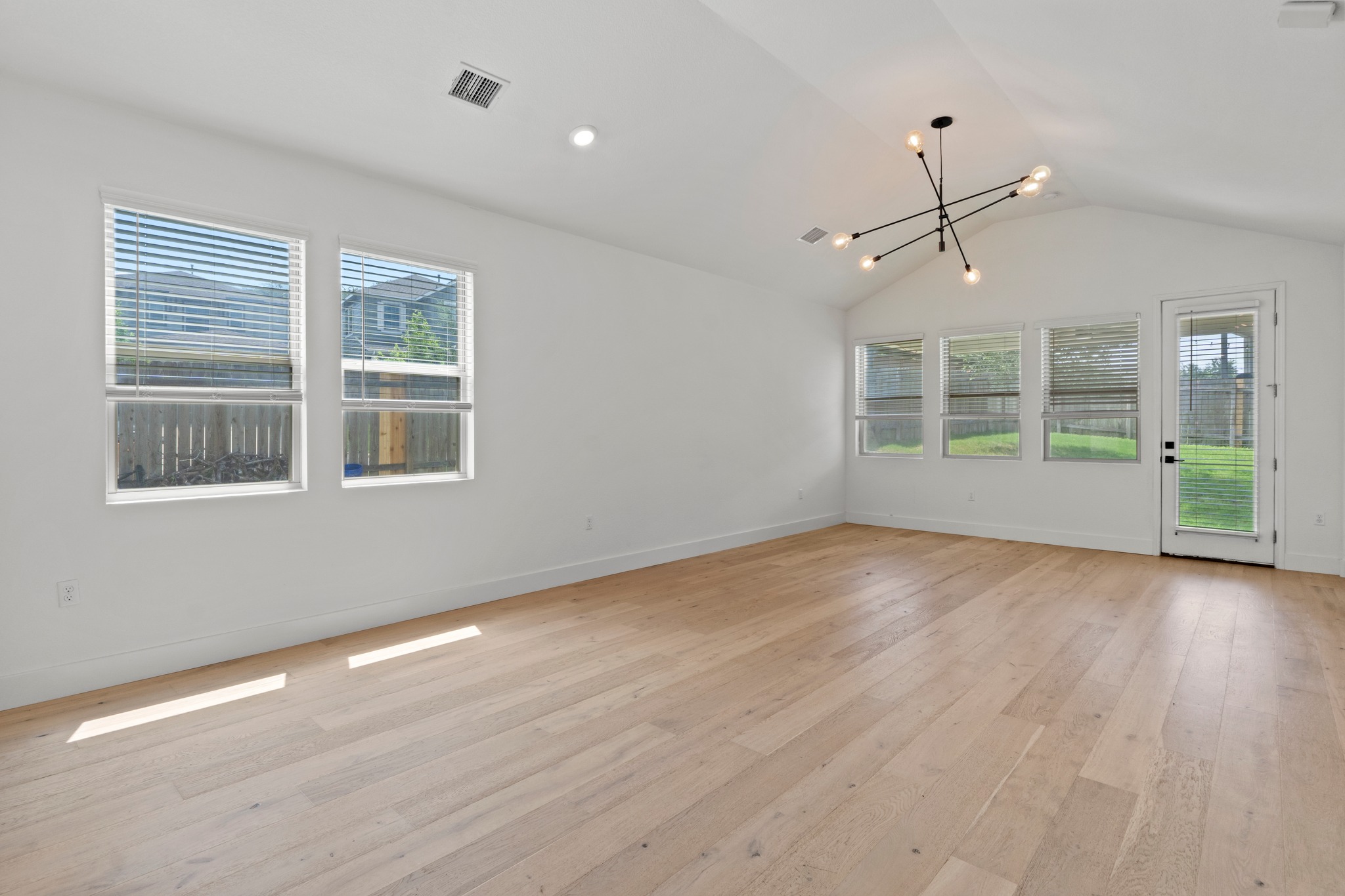 1101 Skeeter Cove Austin, TX 78748 - Photo 5 of 31 Natural light floods this spacious living area, showcasing its soaring vaulted ceilings and polished hardwood flooring.