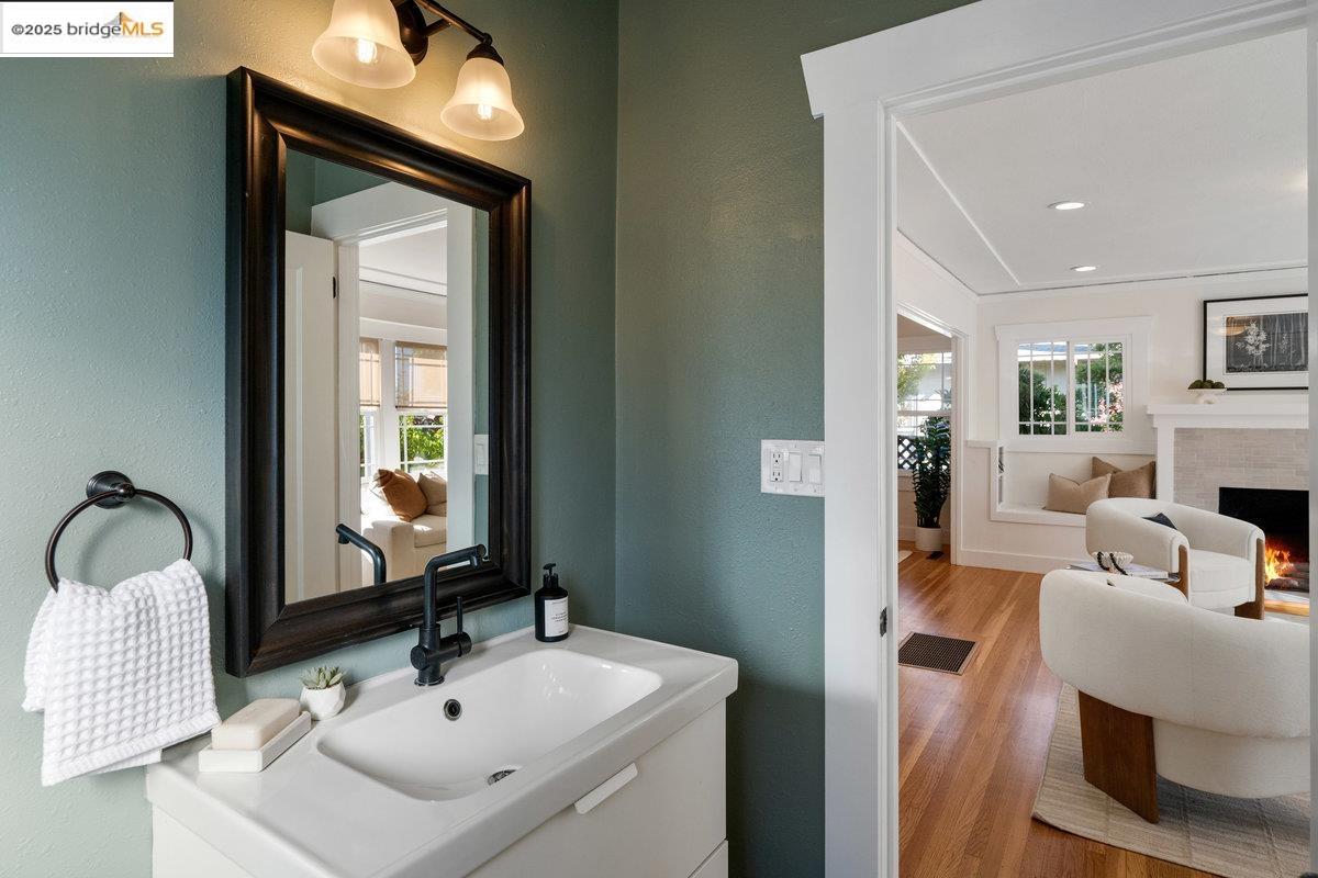 3056 California Street Oakland, CA 94602 - Photo 8 of 44 Bathroom featuring wood finished floors, vanity, a fireplace, and a textured wall