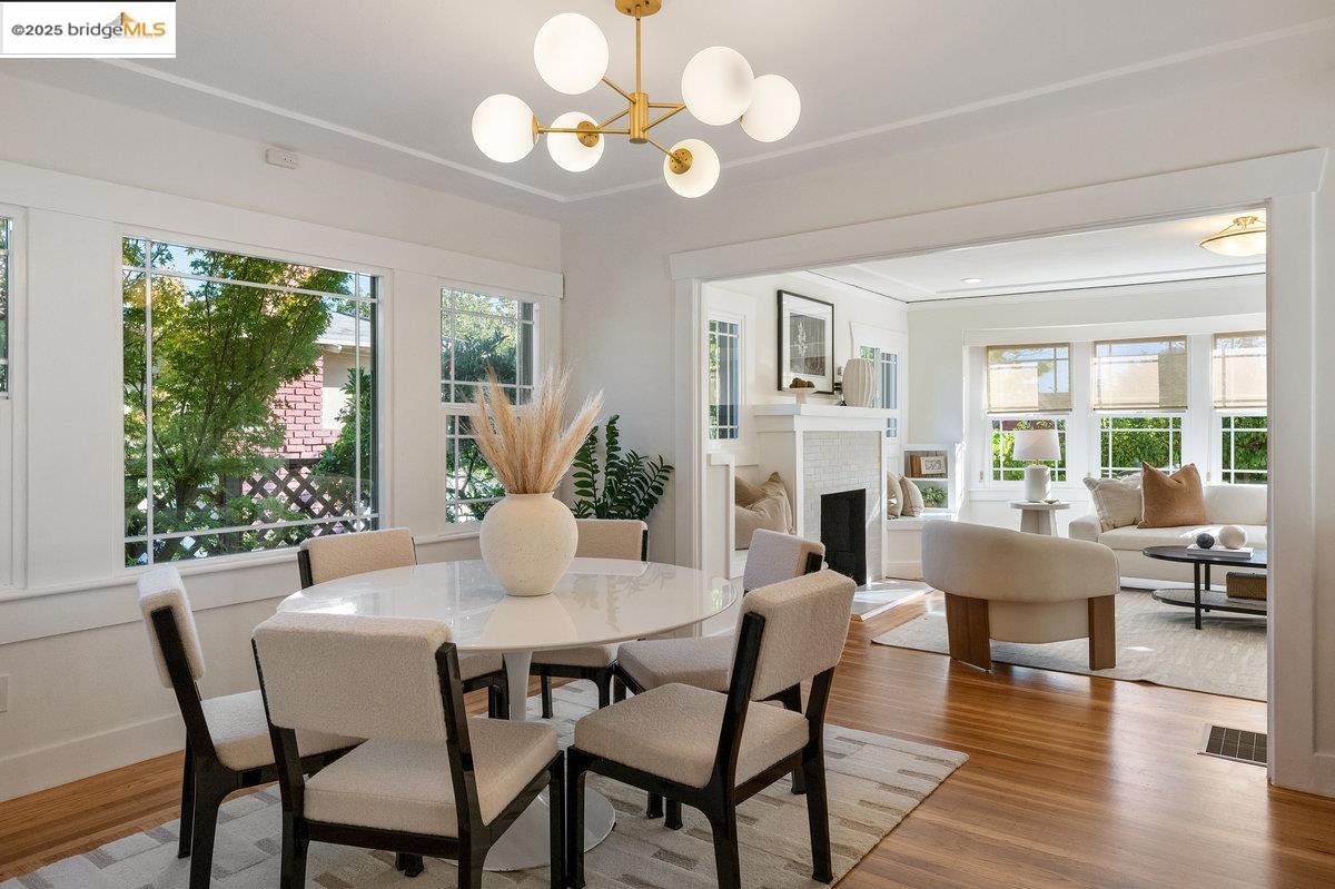 3056 California Street Oakland, CA 94602 - Photo 10 of 44 Dining space featuring wood finished floors, a fireplace with raised hearth, and a chandelier