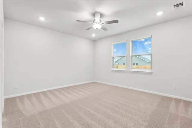 an empty room with fan and windows