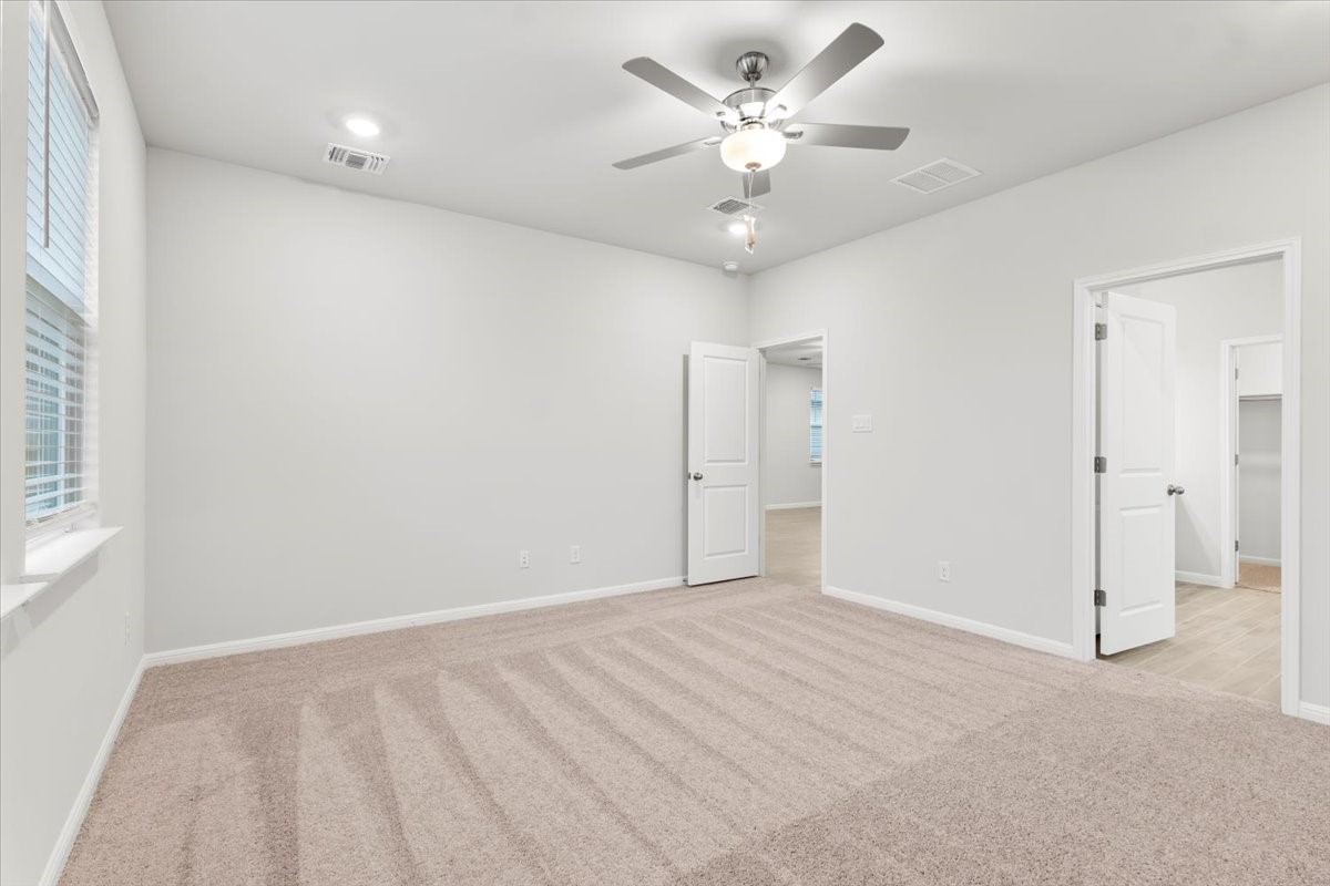 320 Windstar Road Liberty Hill, TX 78642 - Photo 13 of 29 an empty room with a ceiling fan and a window