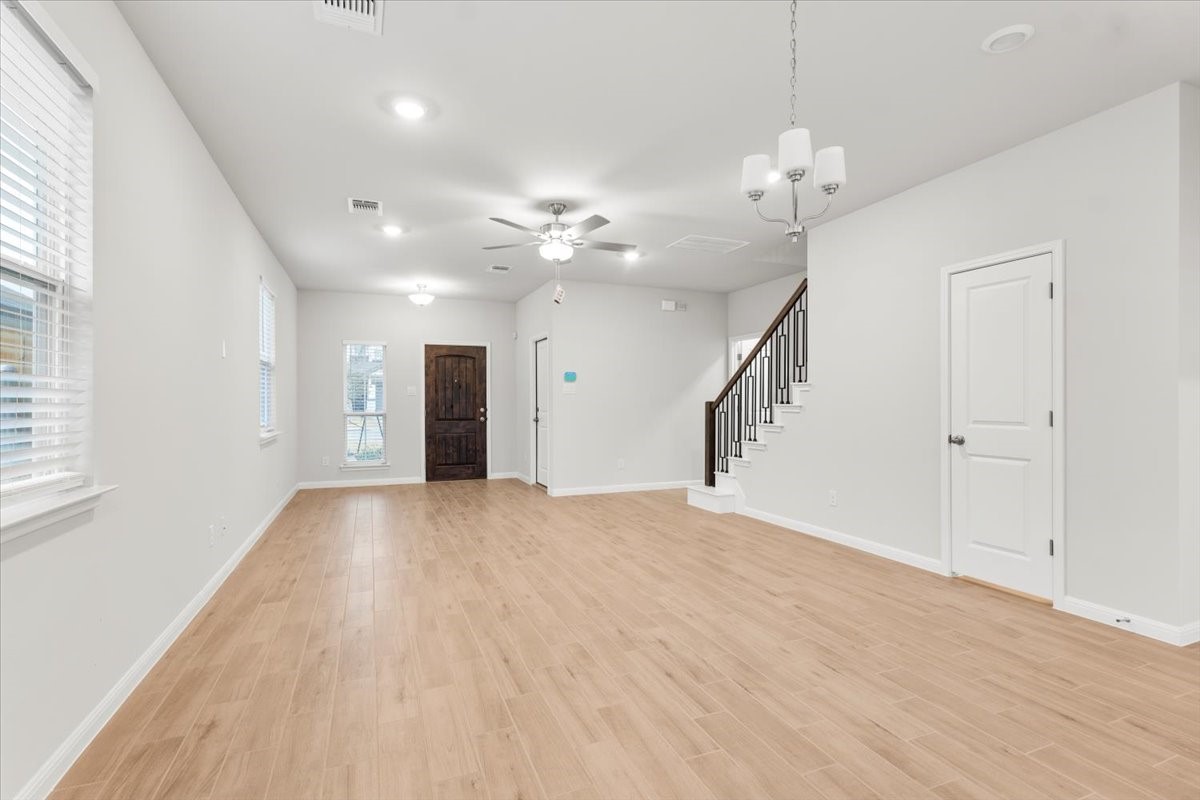 320 Windstar Road Liberty Hill, TX 78642 - Photo 5 of 29 a view of an empty room with wooden floor and a window