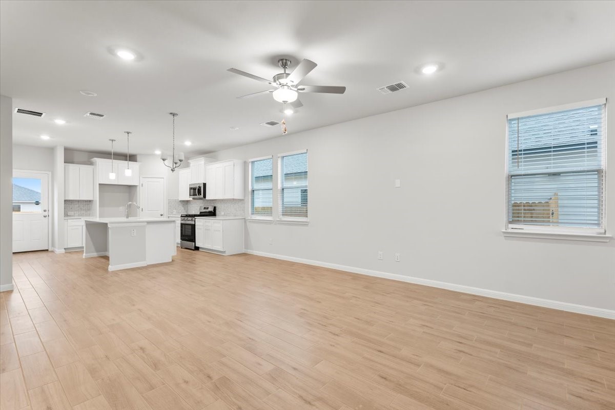 320 Windstar Road Liberty Hill, TX 78642 - Photo 6 of 29 a view of an empty room with kitchen and window