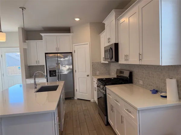a kitchen with kitchen island a sink stainless steel appliances and cabinets