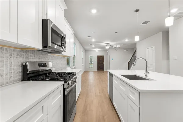 a kitchen with kitchen island a sink stove and cabinets
