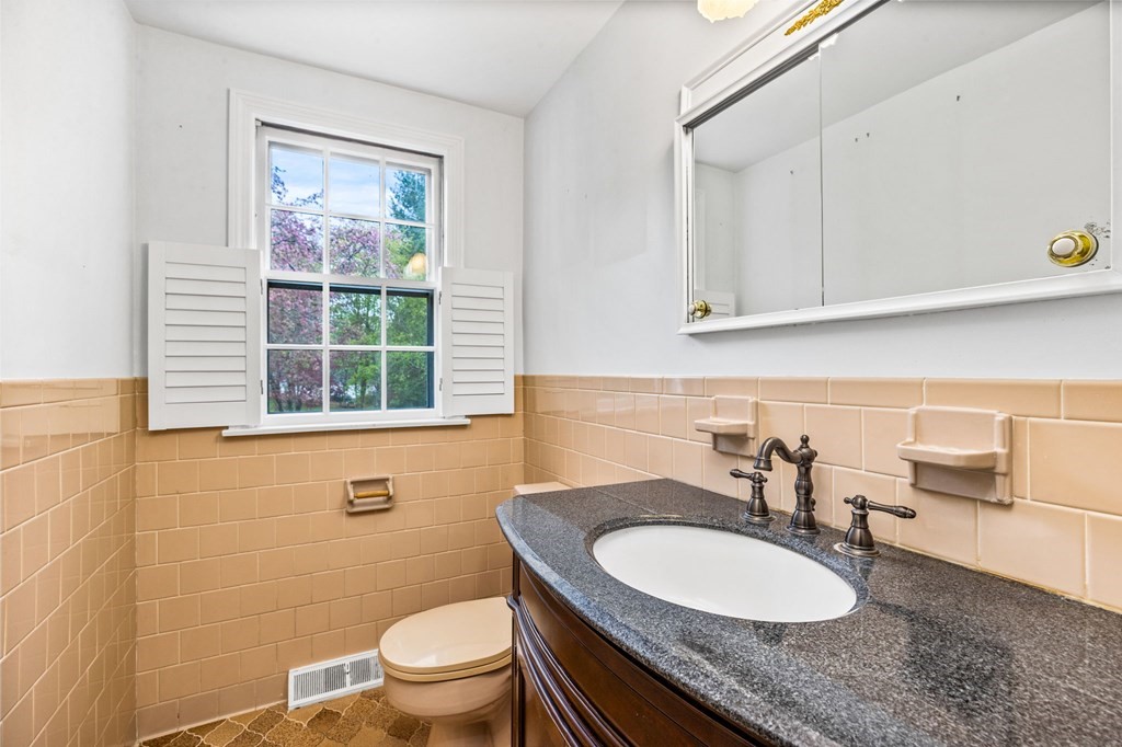 10 Old Coach Road Canton, MA 02021 - Photo 27 of 42 a bathroom with a granite countertop toilet a sink and a mirror