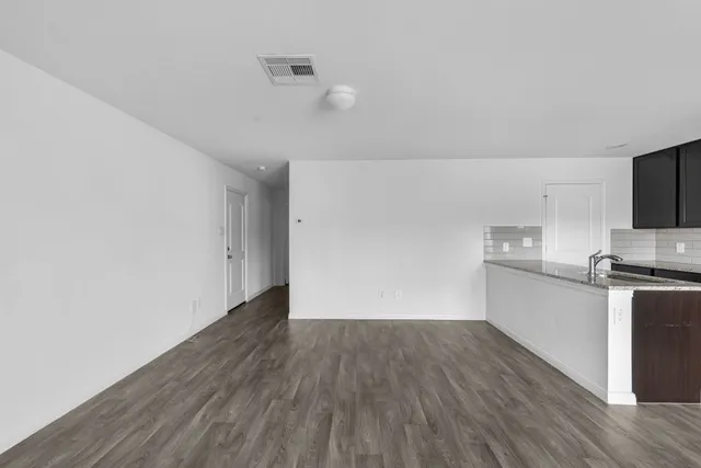 a view of a yard in front of a house with wooden fence