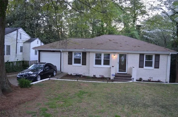 a front view of a house with a garden and yard